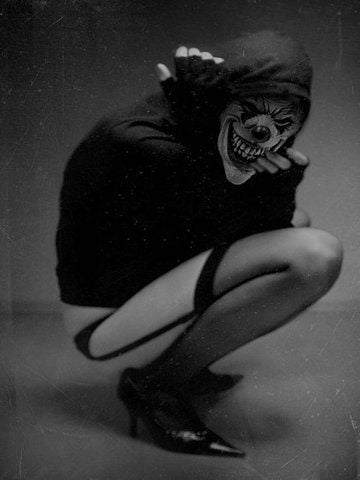 A grinning clown in heels and tights