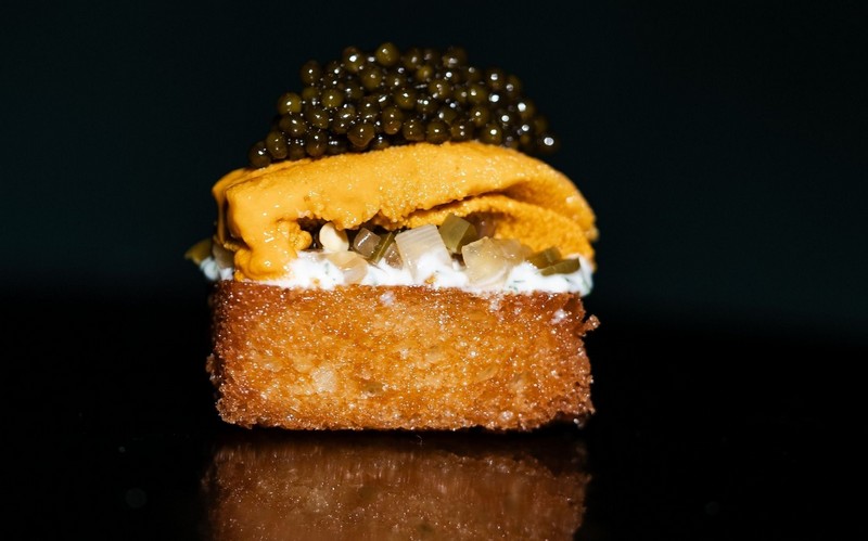 A piece of toast topped with uni and caviar